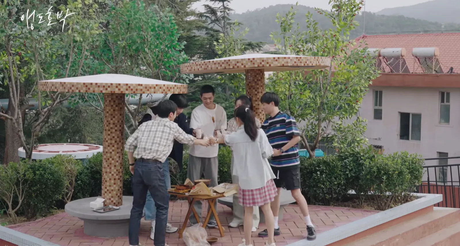 드라마 앵도호박, 사택 단지의 타일 지붕 아래에 여섯 사람이 모여 함께 잔을 부딪치는 장면
